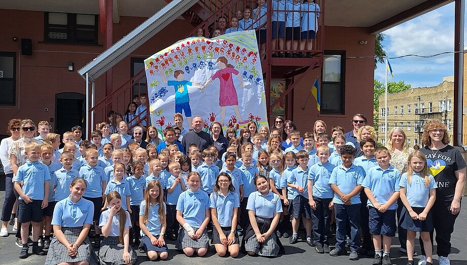 Учні школи св. Миколая в Пассейку НДж. під час події «Діти моляться за дітей в Україні» у. Посередині стоять о. Андрій Дудкевич та с. Кетлін Гацко. (31 травня 2024)