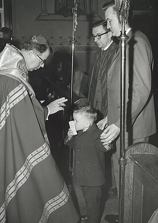 Владика Амброзій Сенишин благословляє маленького парафіянина на парафії св. Володимира у Елізабет, НДж (8 квітня 1962)